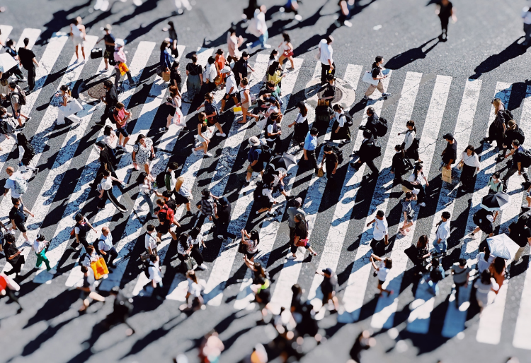 Image of many people walking across a crossing